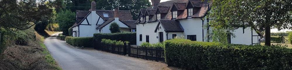 A photo of two houses in the countryside, taken from the road